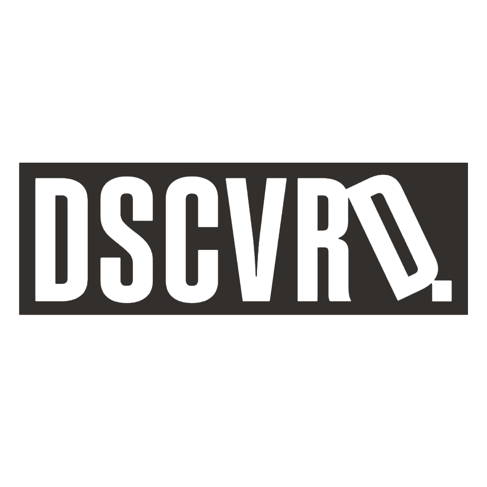 A black and white image with a large, prominently displayed sign that reads 'DSCVRD.' in bold, capital letters. Logo for Discovered Magazine