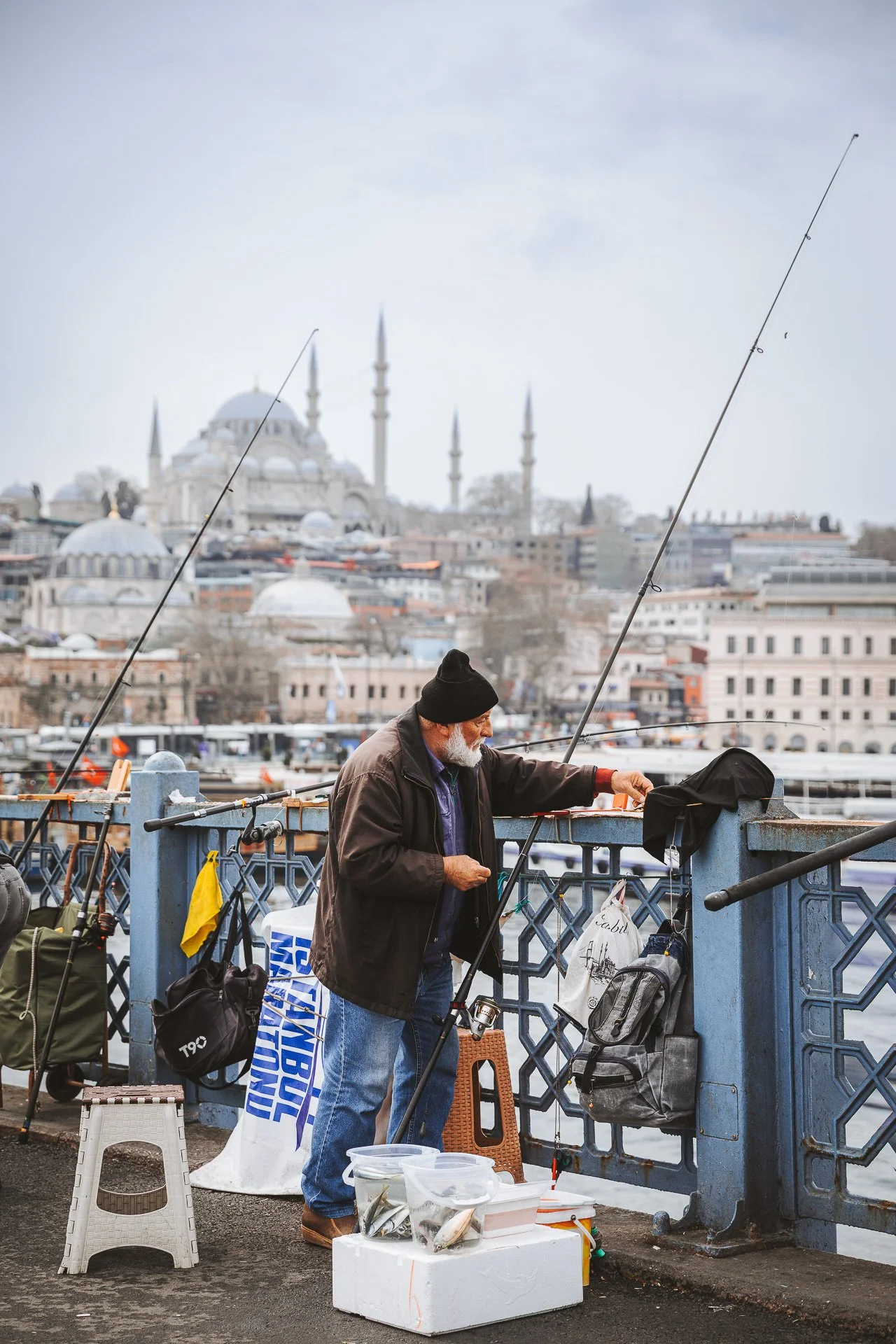 Ein alter Mann fängt am Fluss in Istanbul, Türkei, Fische. Hinter ihm ist die Hagia Sophia zu sehen.