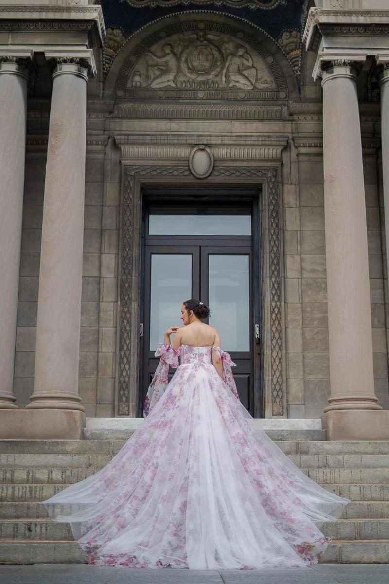 Bride in a floral gown standing on courthouse steps