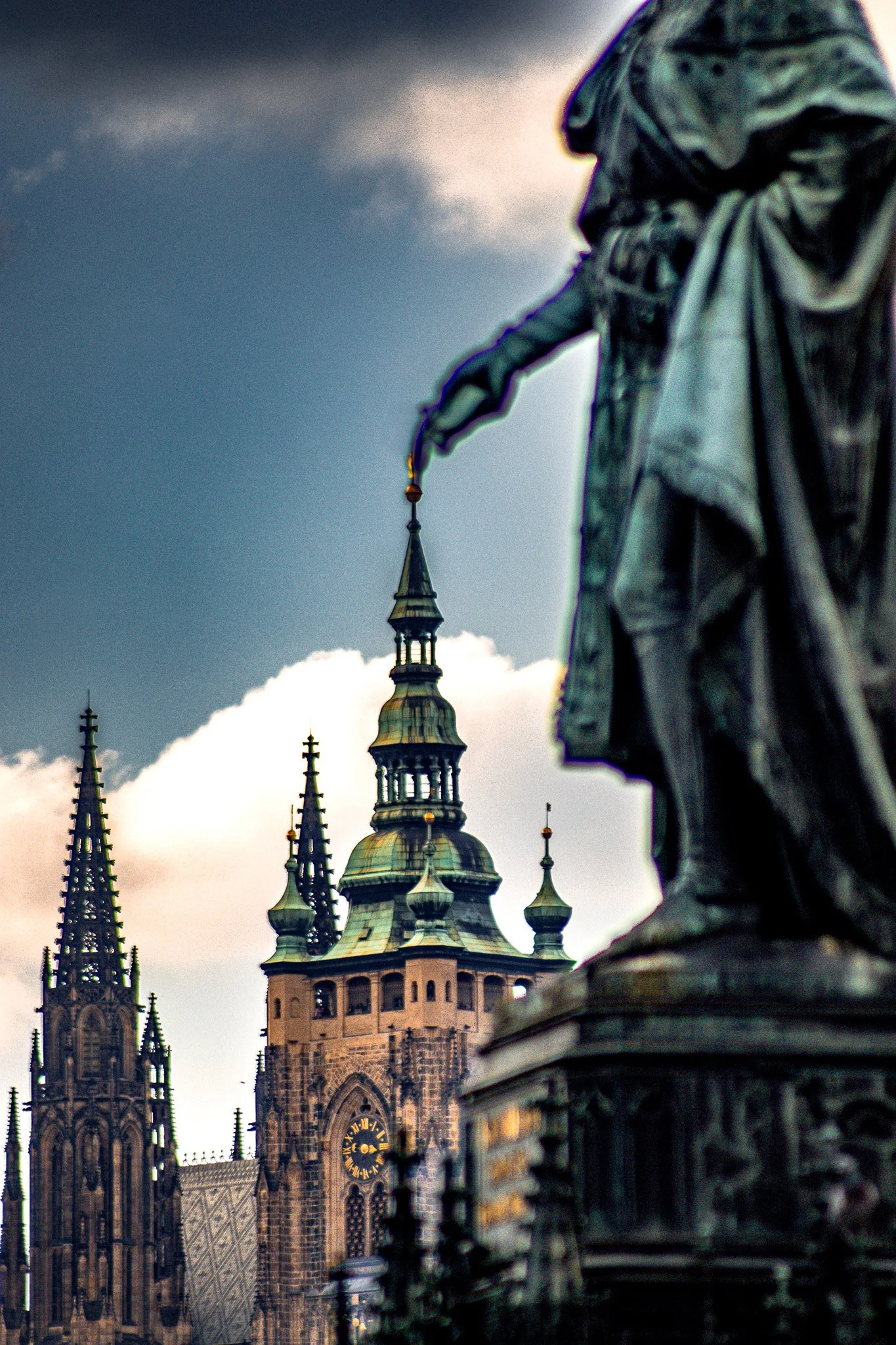Close-up of a gothic-style cathedral spire with a statue in the foreground.