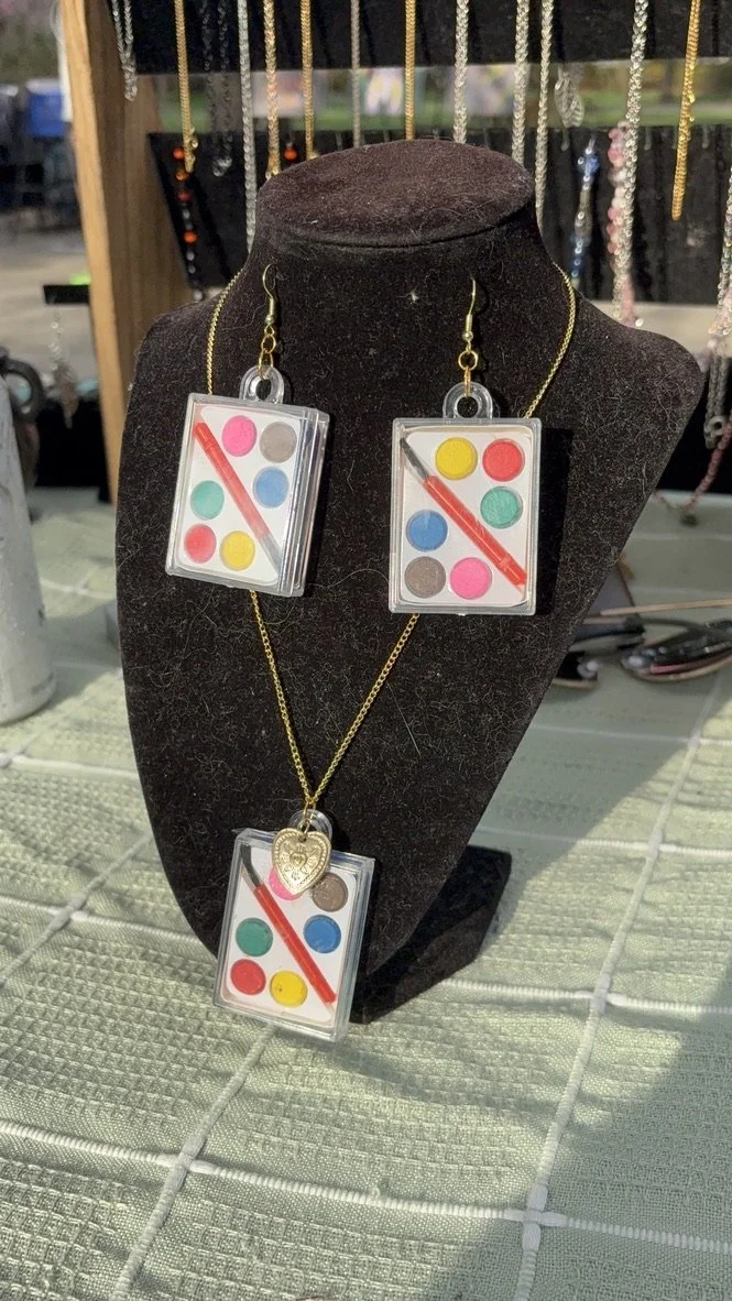 Necklace and earrings jewelry set with domino tile designs on a black display bust, featuring colorful dots and red lines.