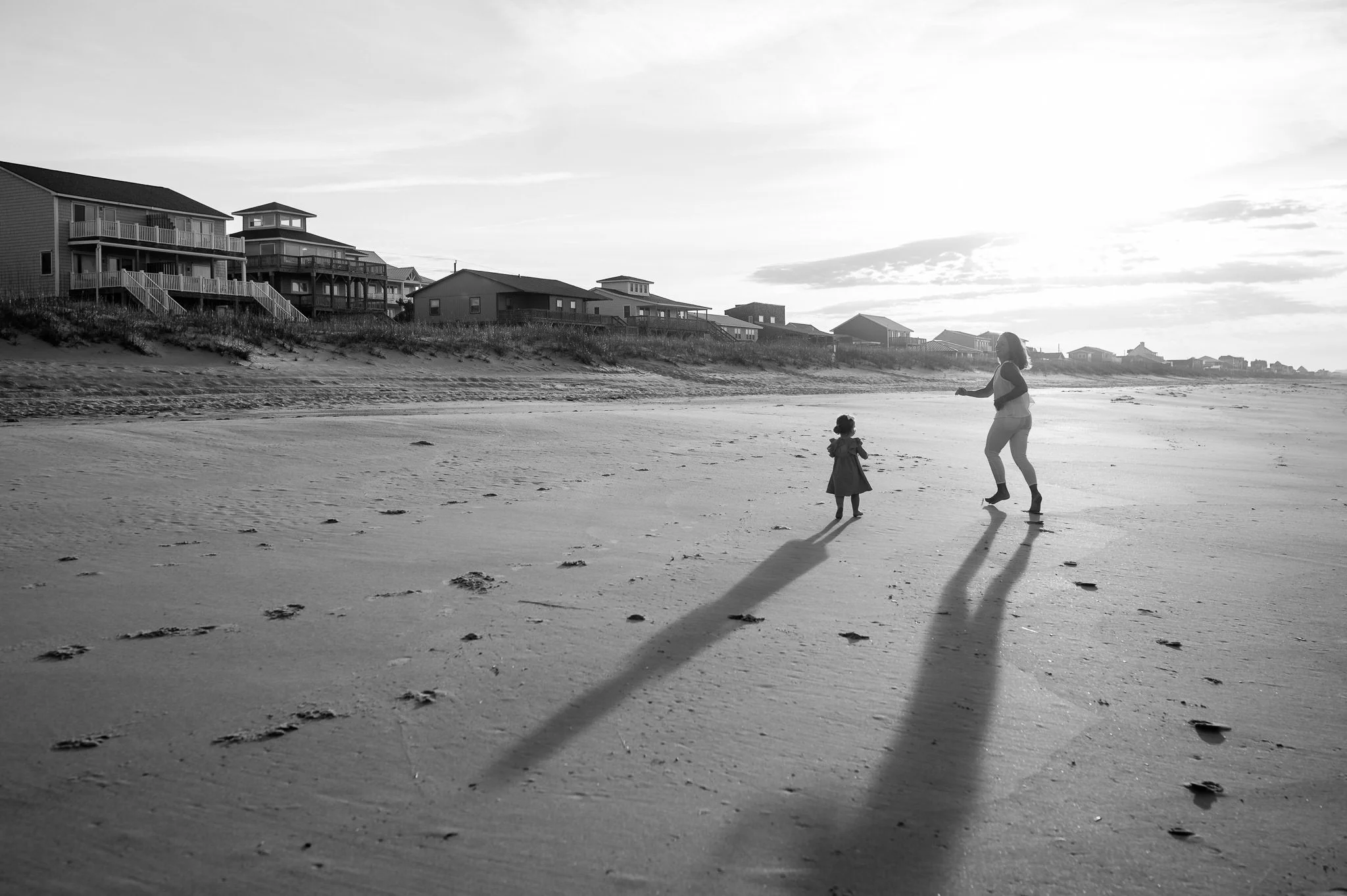 Mother and daughter running along coastline in lifestyle natural photos by Elise Souders, photographer