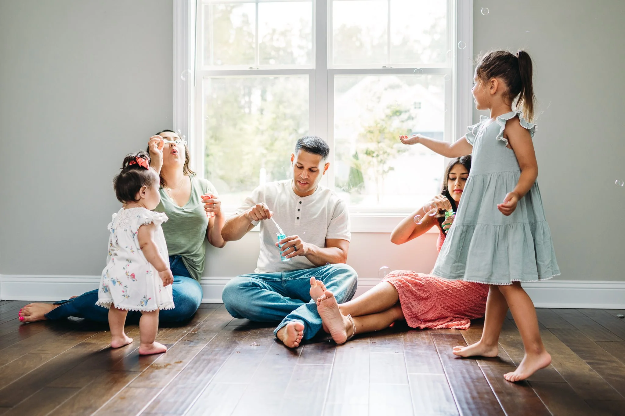 Candid family photo blowing bubbles at home by Elise Souders, Bend, Oregon Photographer