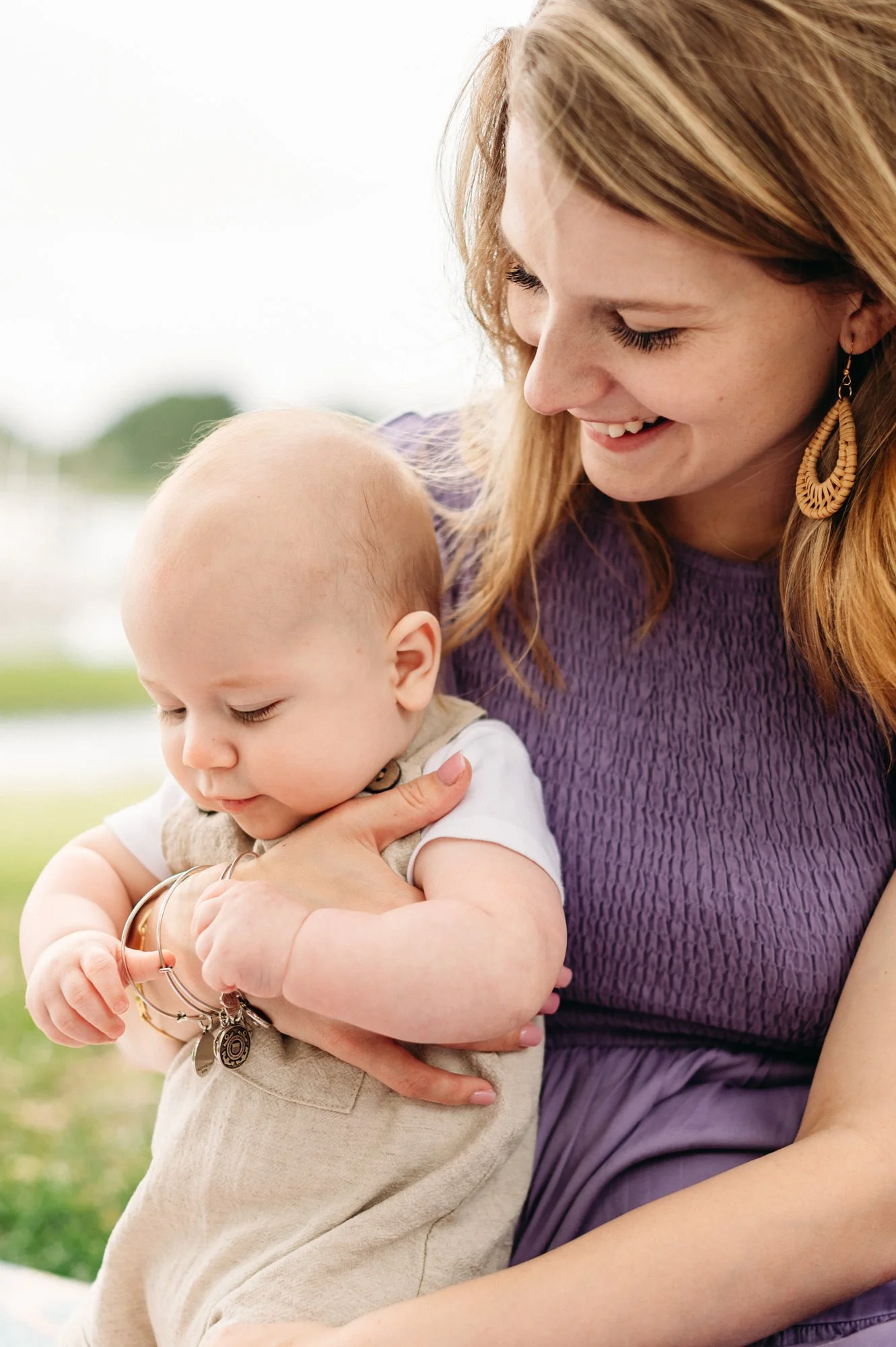 Parent and child outside in Drake Park, smiling as they play on a blanket. Motherhood photo by Elise Souders, Bend Oregon Photographer