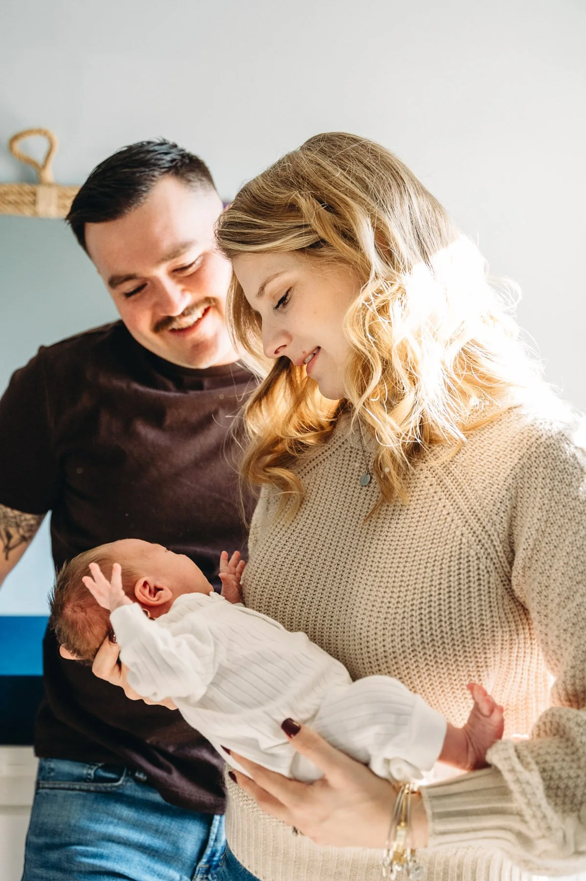 Parents holding young baby in the nursery, candid moment by Bend Family Photographer Elise Souders