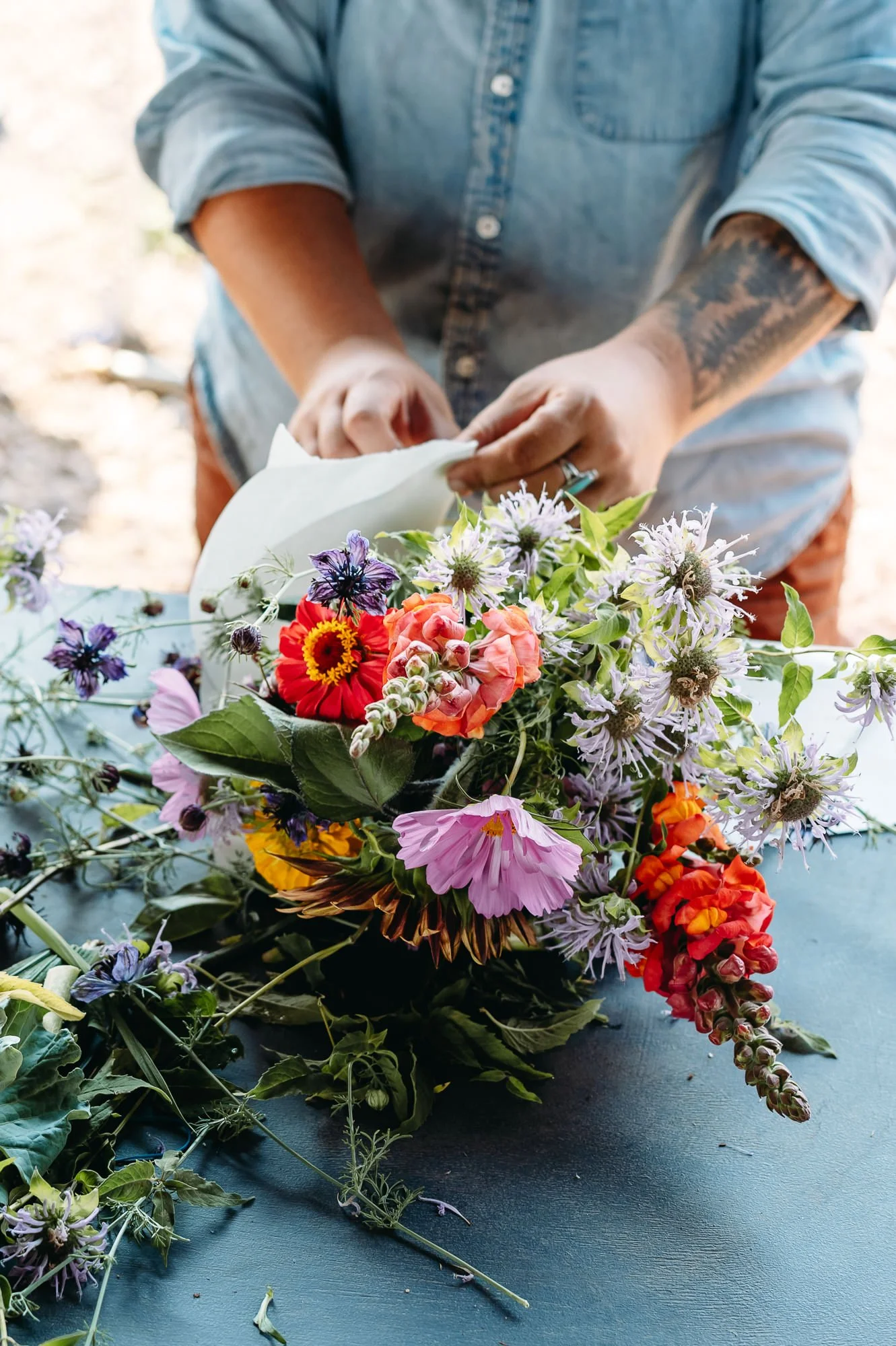 Woman's hands finishing a bouquet of colorful flowers, branding photo by Elise Souders.