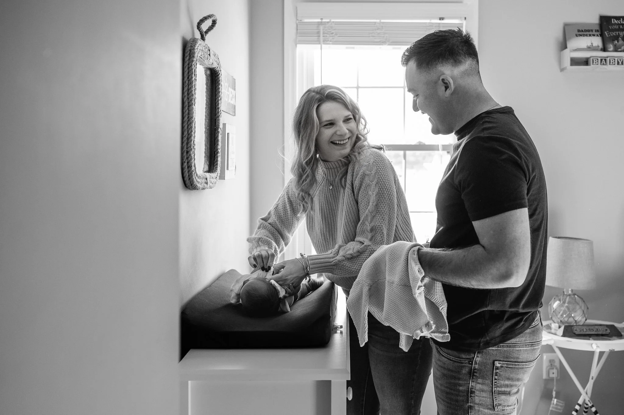 New parents laughing while changing their baby's clothes, in-home newborn session Bend, Oregon by Elise Souders, photographer