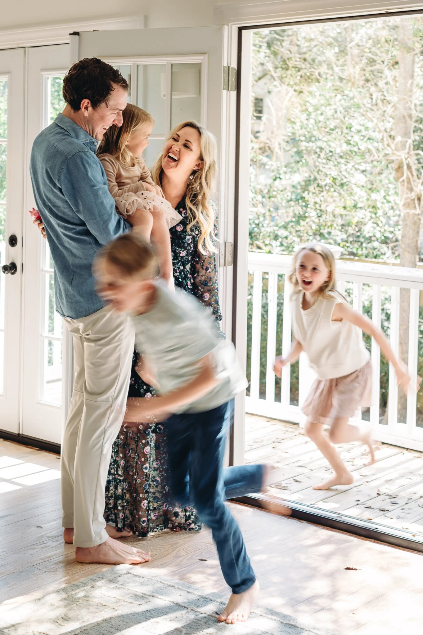 Two children blurred by the camera as they quickly run past parents, candid family photography by Elise Souders in Bend, Oregon