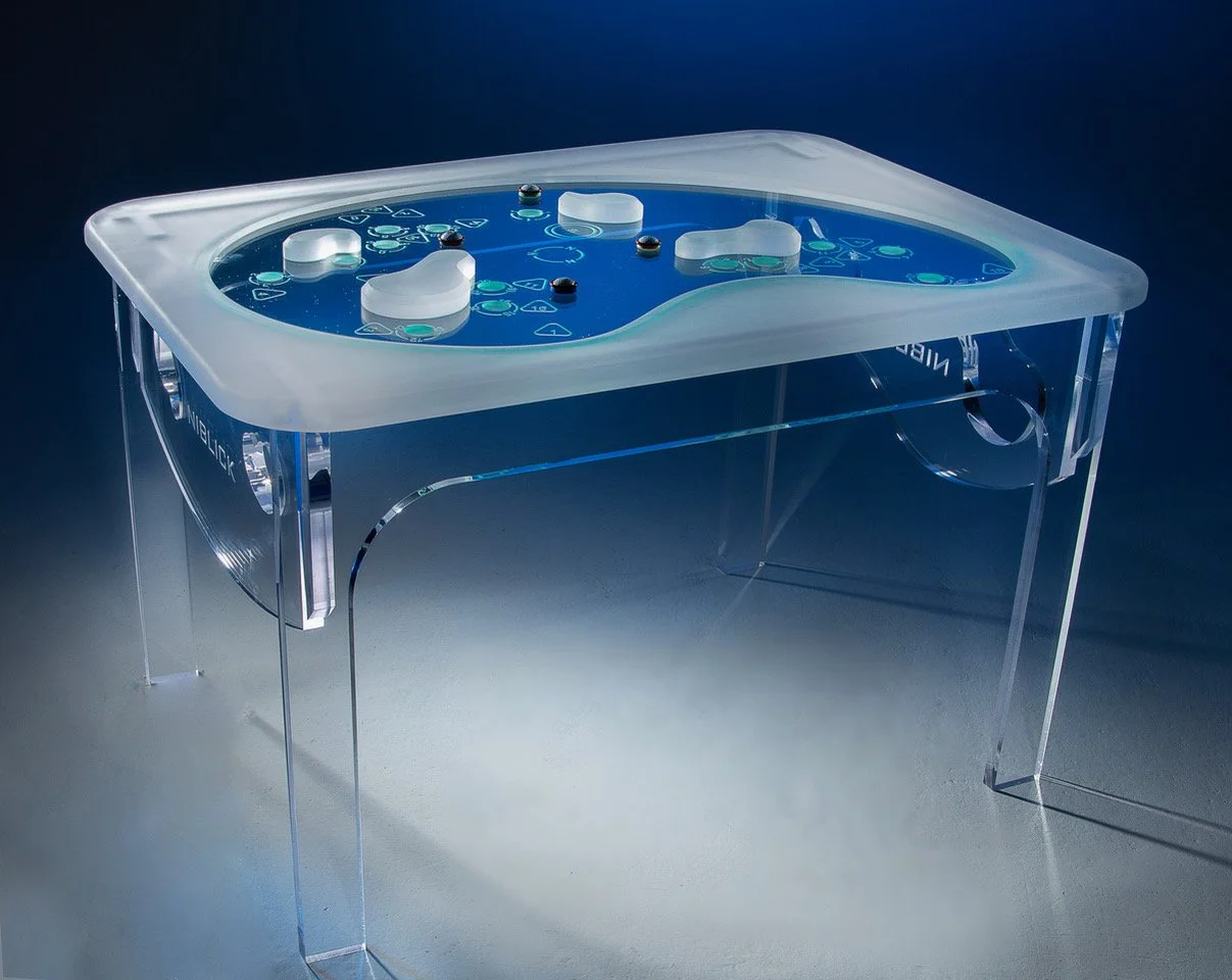 A transparent table with a blue gaming board on top, featuring white and black game pieces and circular tokens, used for playing a tabletop game.