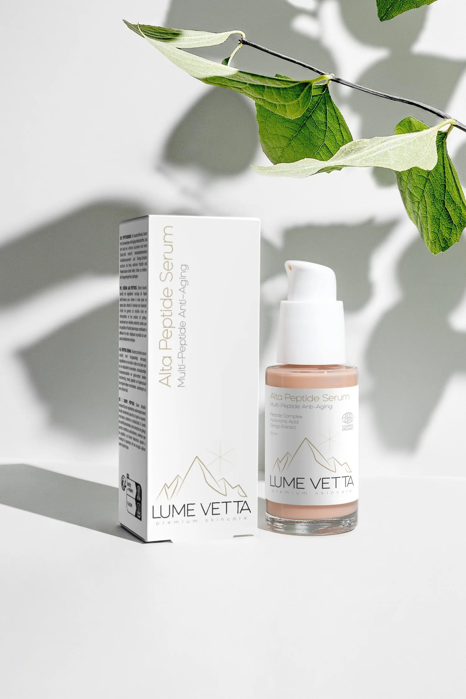 Ein Fläschchen mit Anti-Aging Serum und seine Verpackung auf einem weißen Hintergrund, mit grünem Blatt als Dekoration