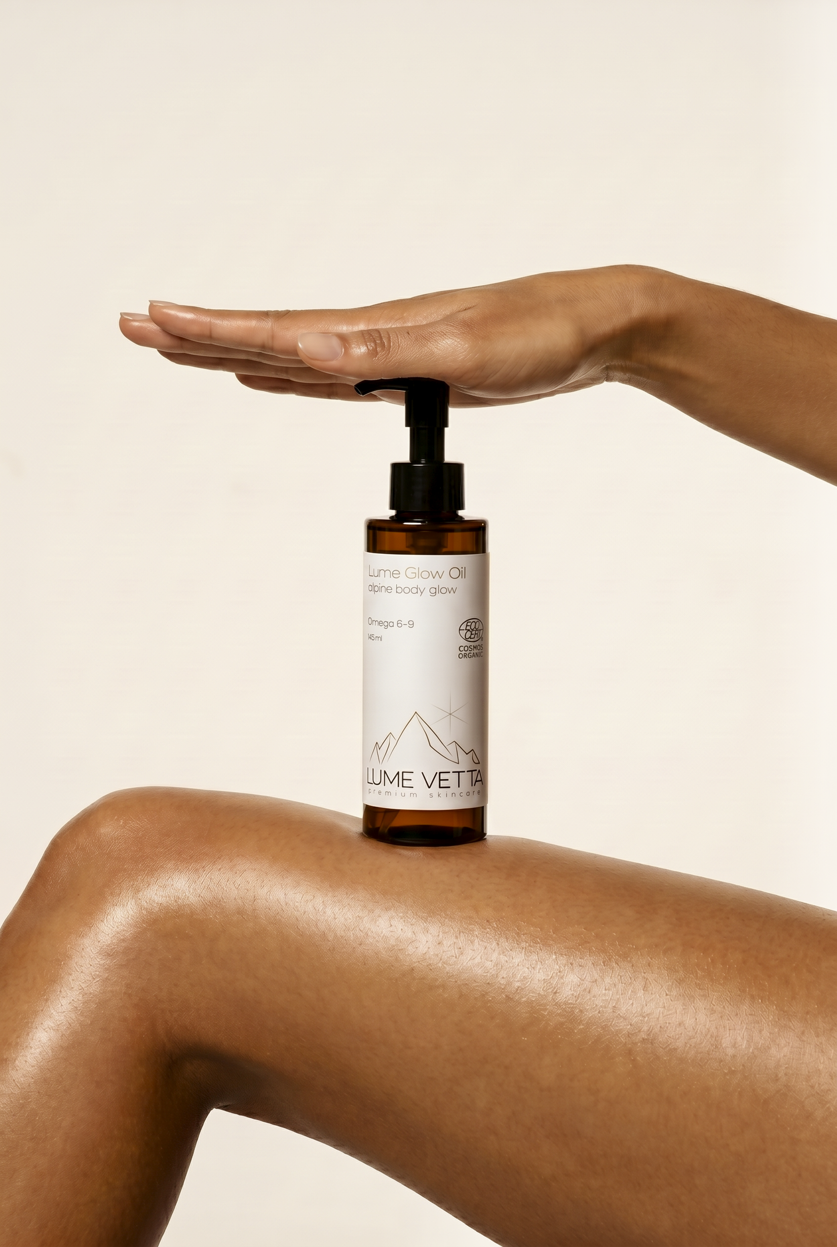 Hand hält eine Flasche Lume Glow Oil auf einer rundlichen Schulter. Das Öl hat eine organische, natürliche Atmosphäre.