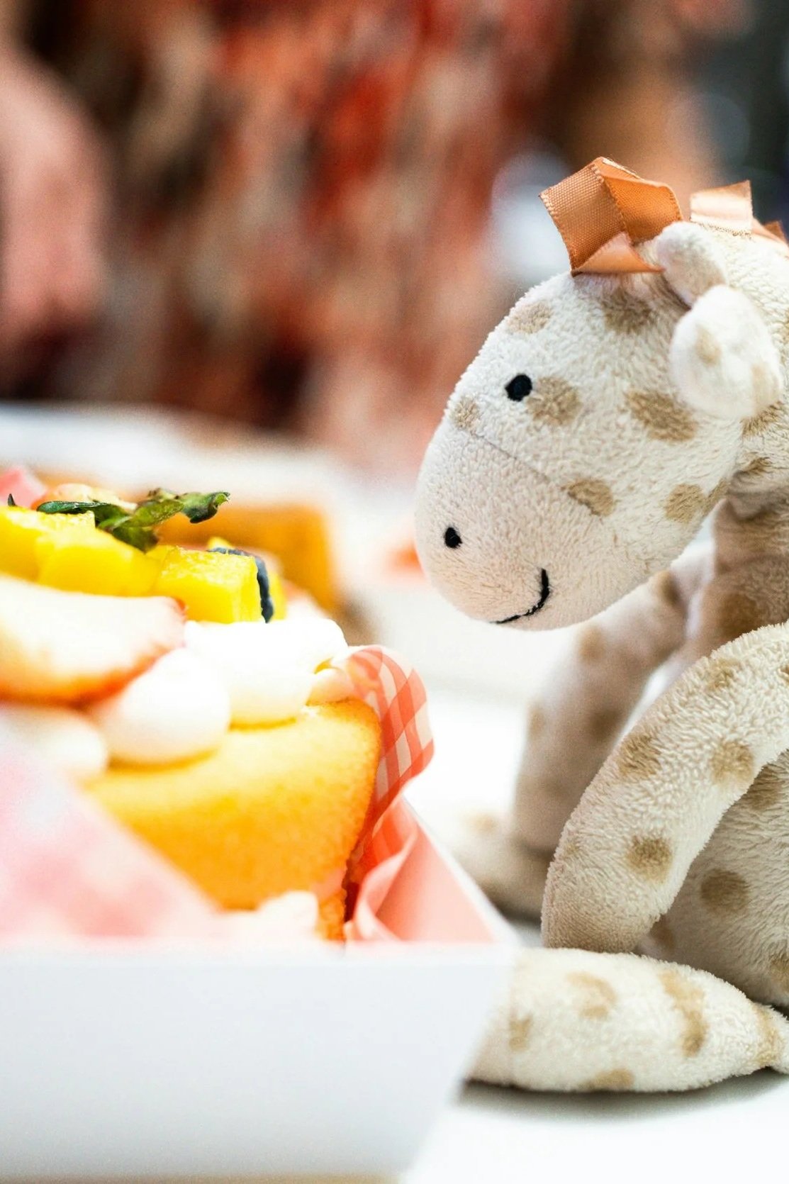 장난감 기린 인형이 케이크를 바라보는 모습.
