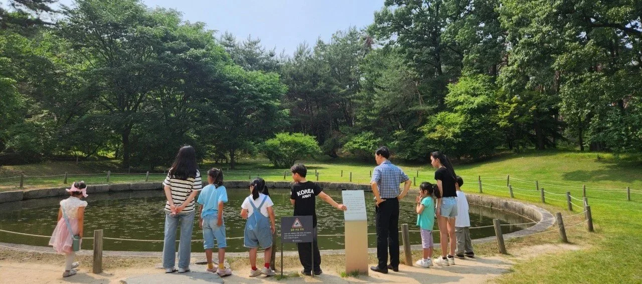공원에 모여 있는 사람들, 연못 주변에서 아이들과 어른들이 볼 수 있습니다.