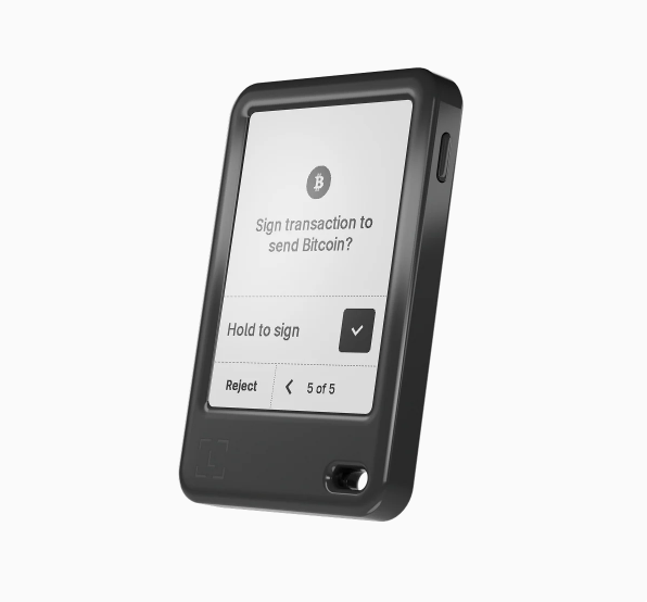 A mobile device screen displaying a prompt to sign a Bitcoin transaction, with options to hold to sign or reject.