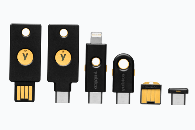 Collection of black and gold Yubico security keys and USB hardware security tokens.