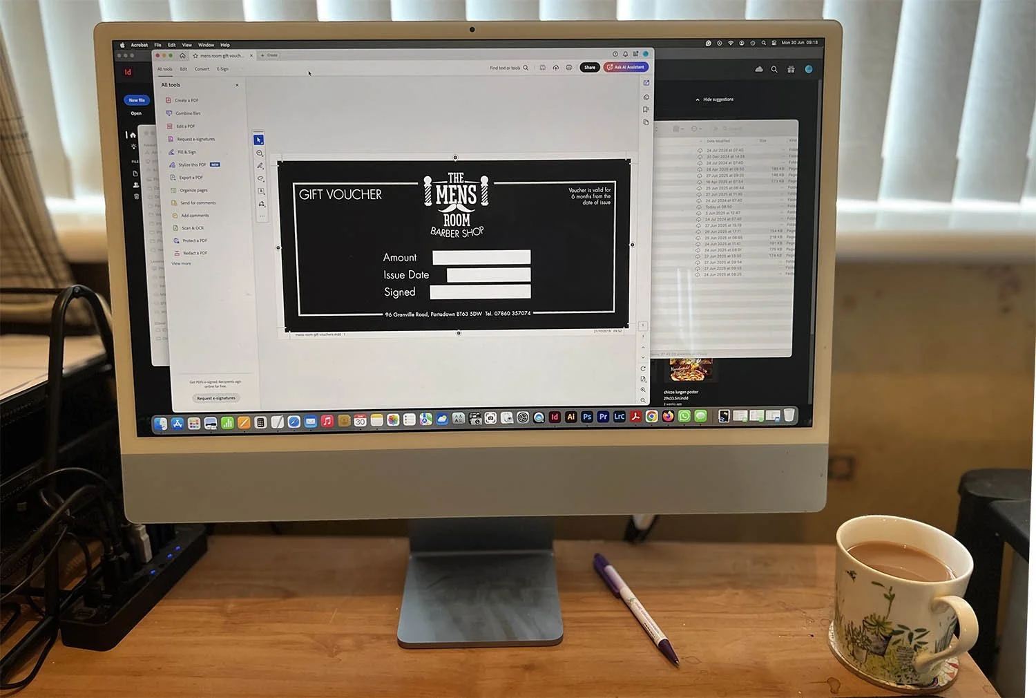 Wide photo of my computer set up using the latest Apple Mac technology, showing the graphic design I am working on.