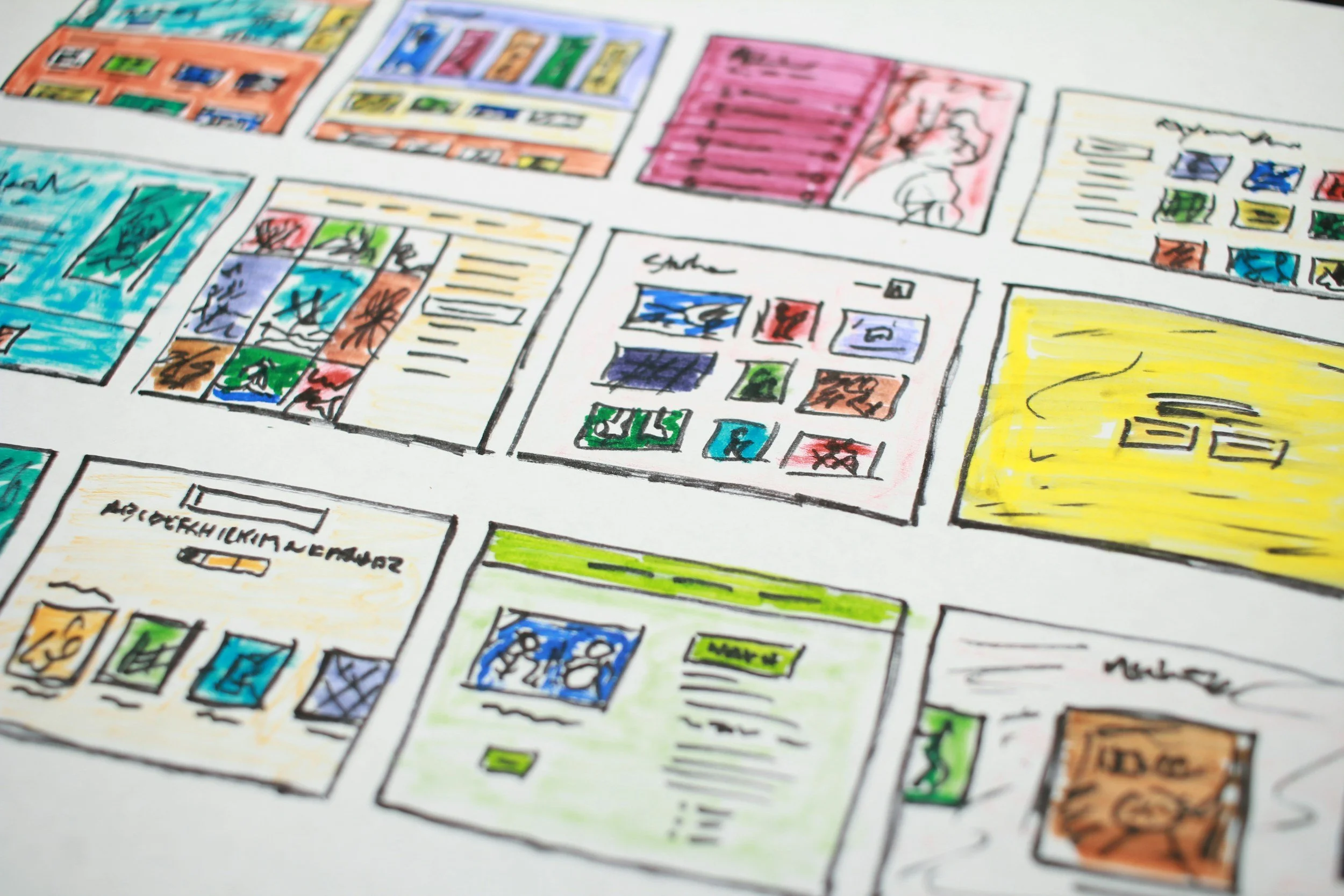 colored drawings that create a storyboard for a website . Colors from lime green, to purple to pink to blue and more. Black writing on papers