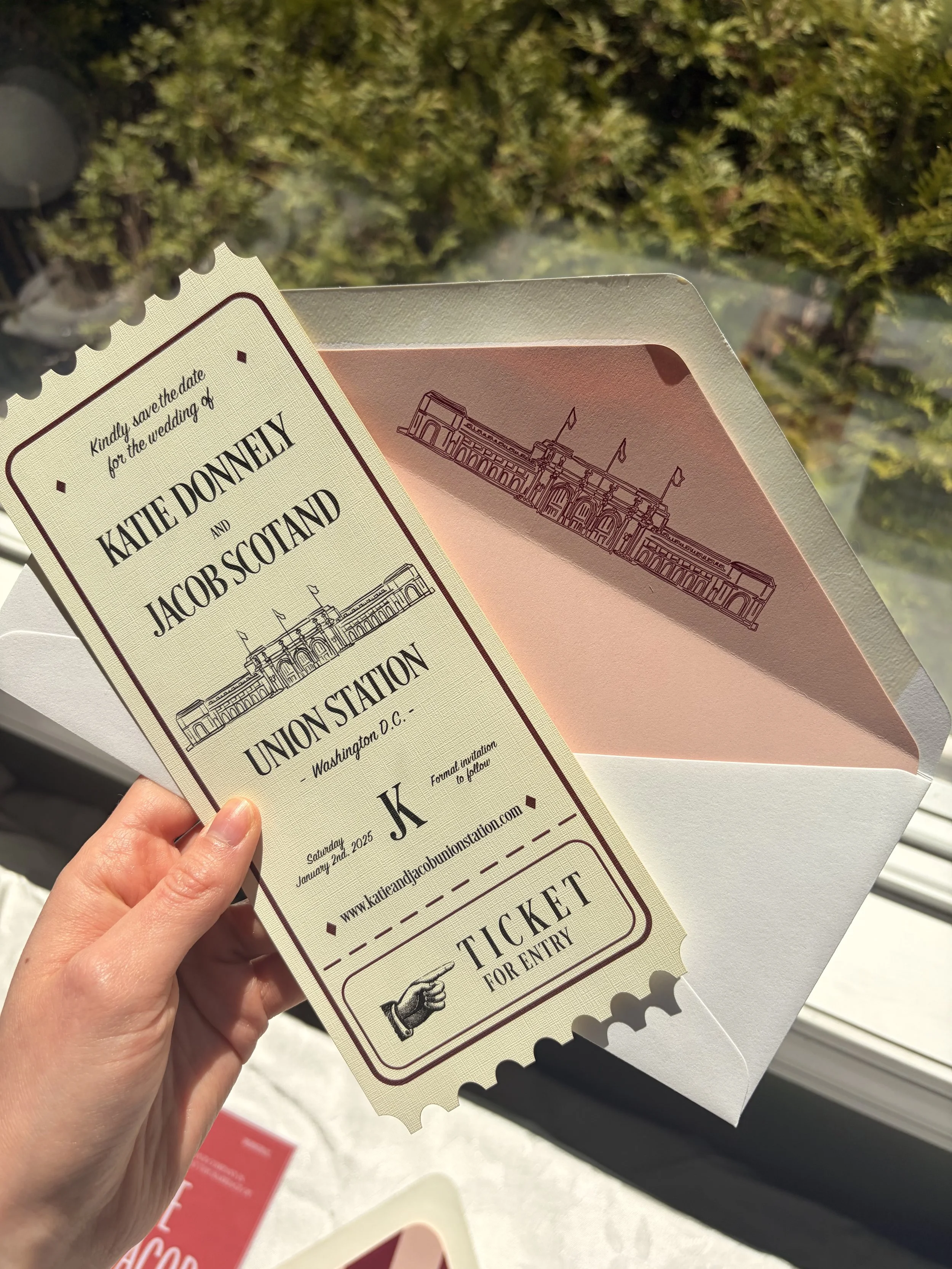 A wedding invitation resembling a ticket, featuring an illustration of Union Station in Washington D.C., hand design and illustrations creatively and uniquely put together.