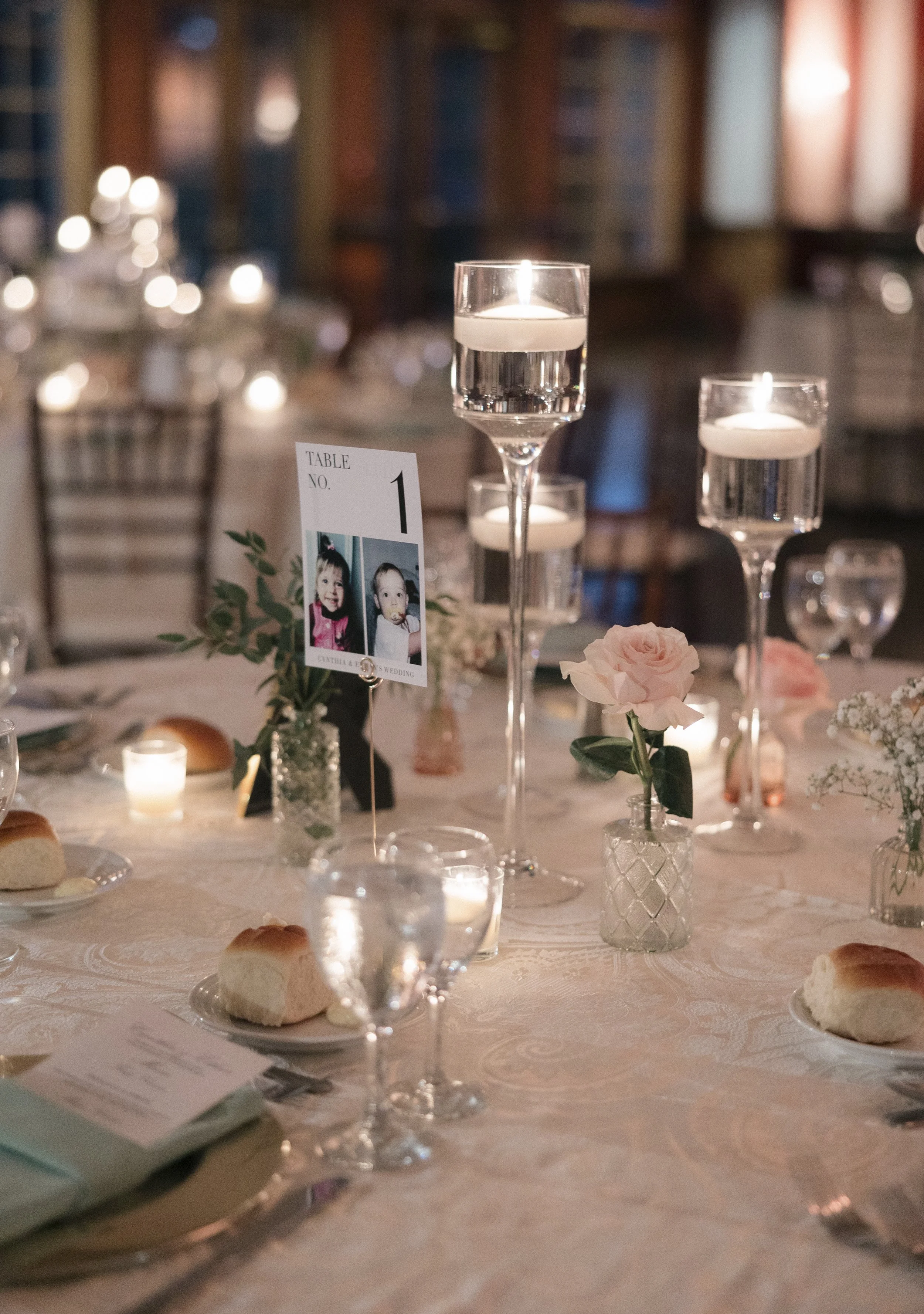 Wedding reception table decorated with custom baby picture table number signs.