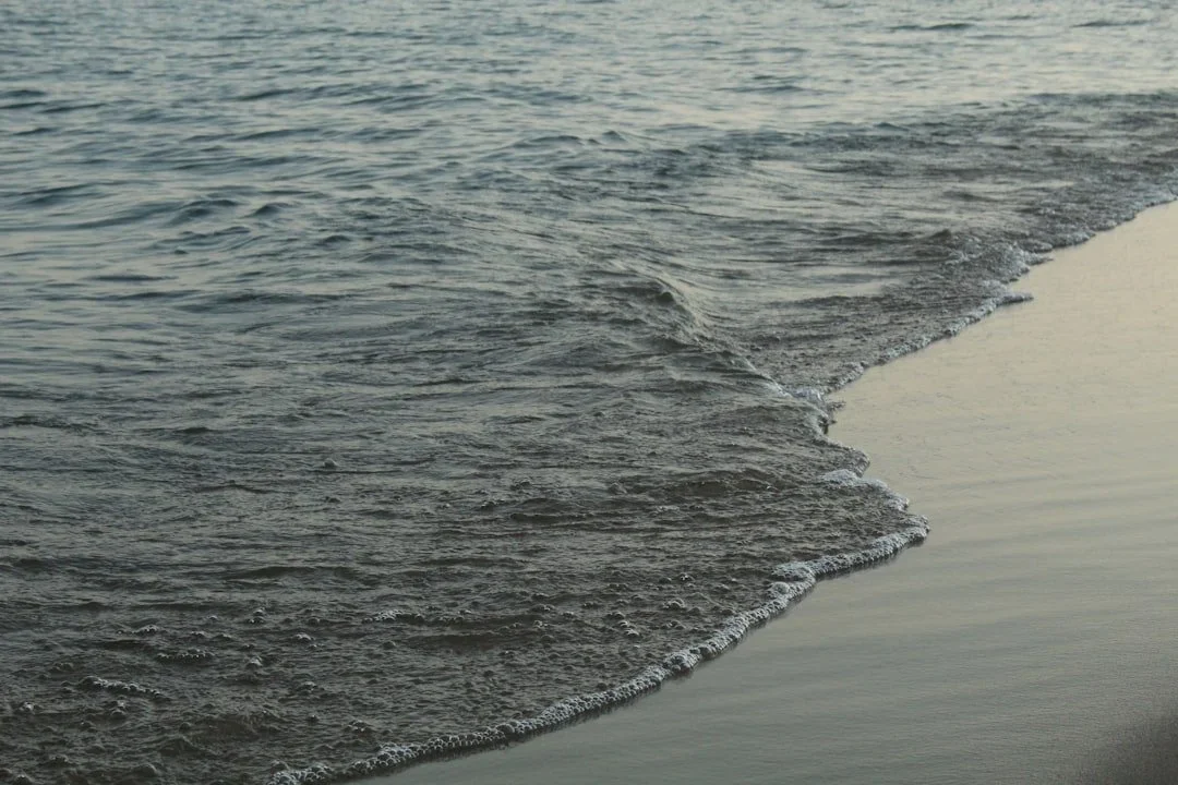 Close-up of ocean waves washing onto a sandy beach during daytime