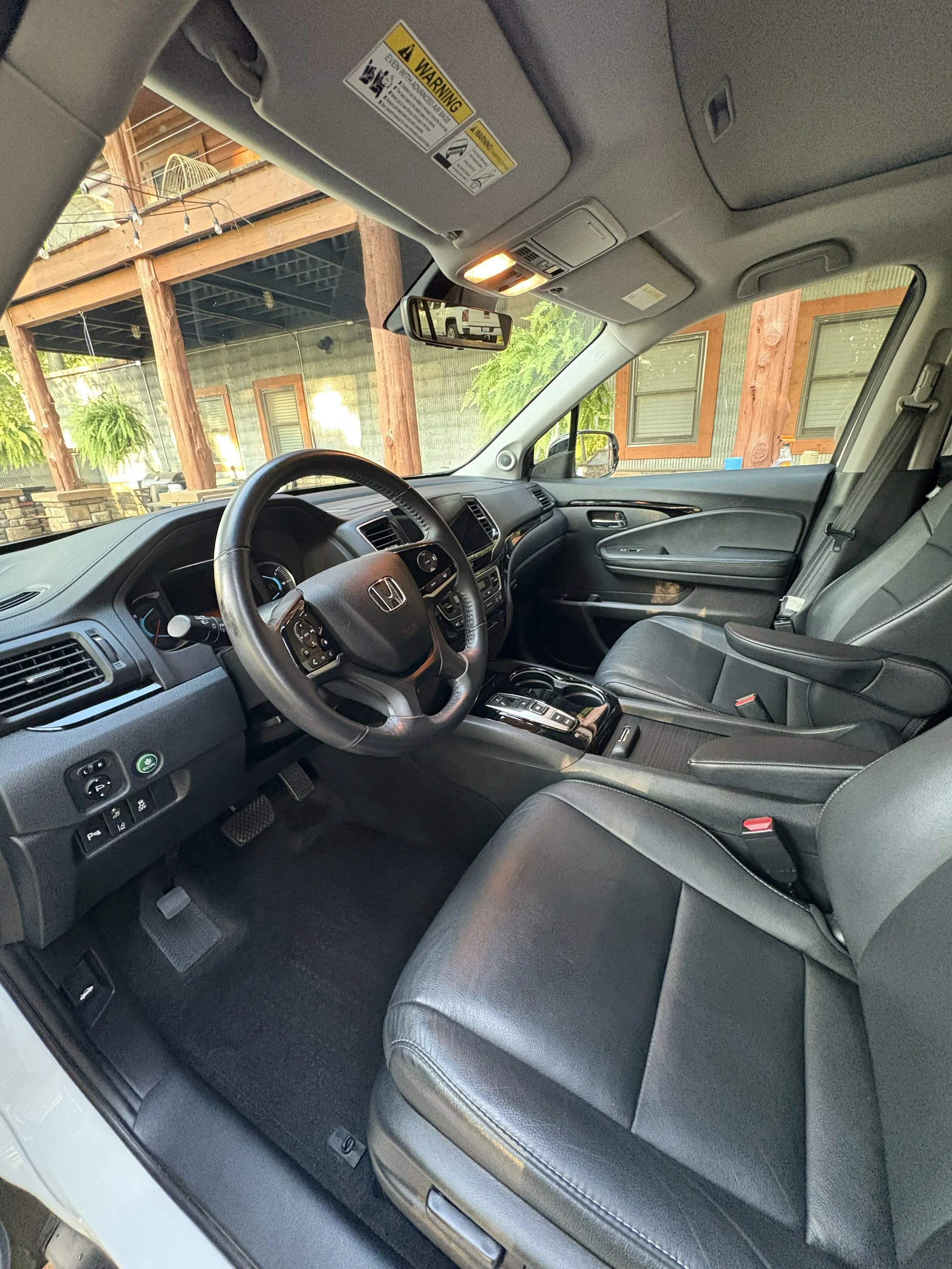 Interior of a clean Honda SUV showing the front seats, steering wheel, dashboard, and center console after receiving an interior mobile detail in Hopkinsville, KY.
