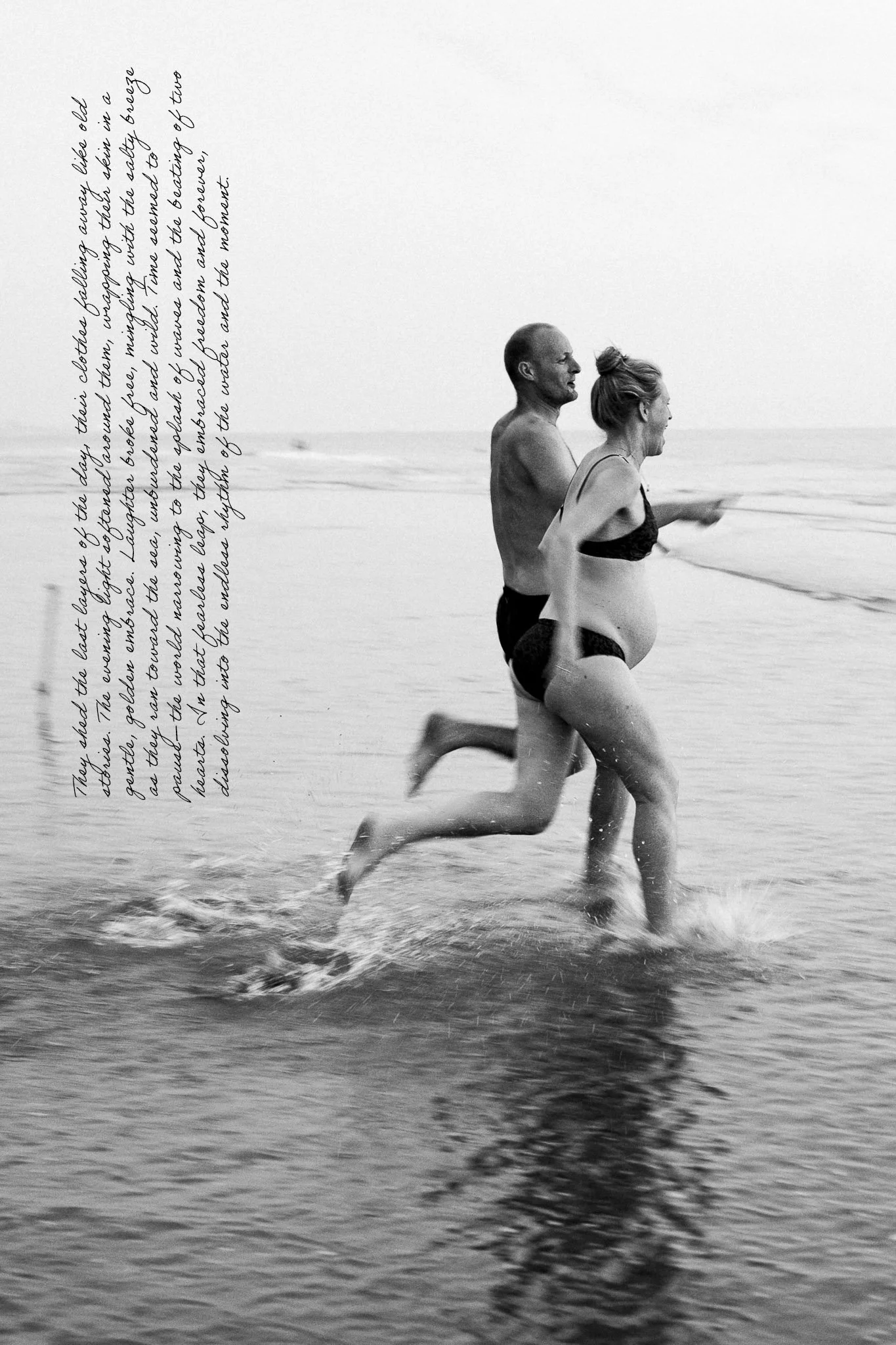 Zwevende zwart-wit foto van een man en een zwangere vrouw die samen rennen in de zee, met een horizon op de achtergrond.