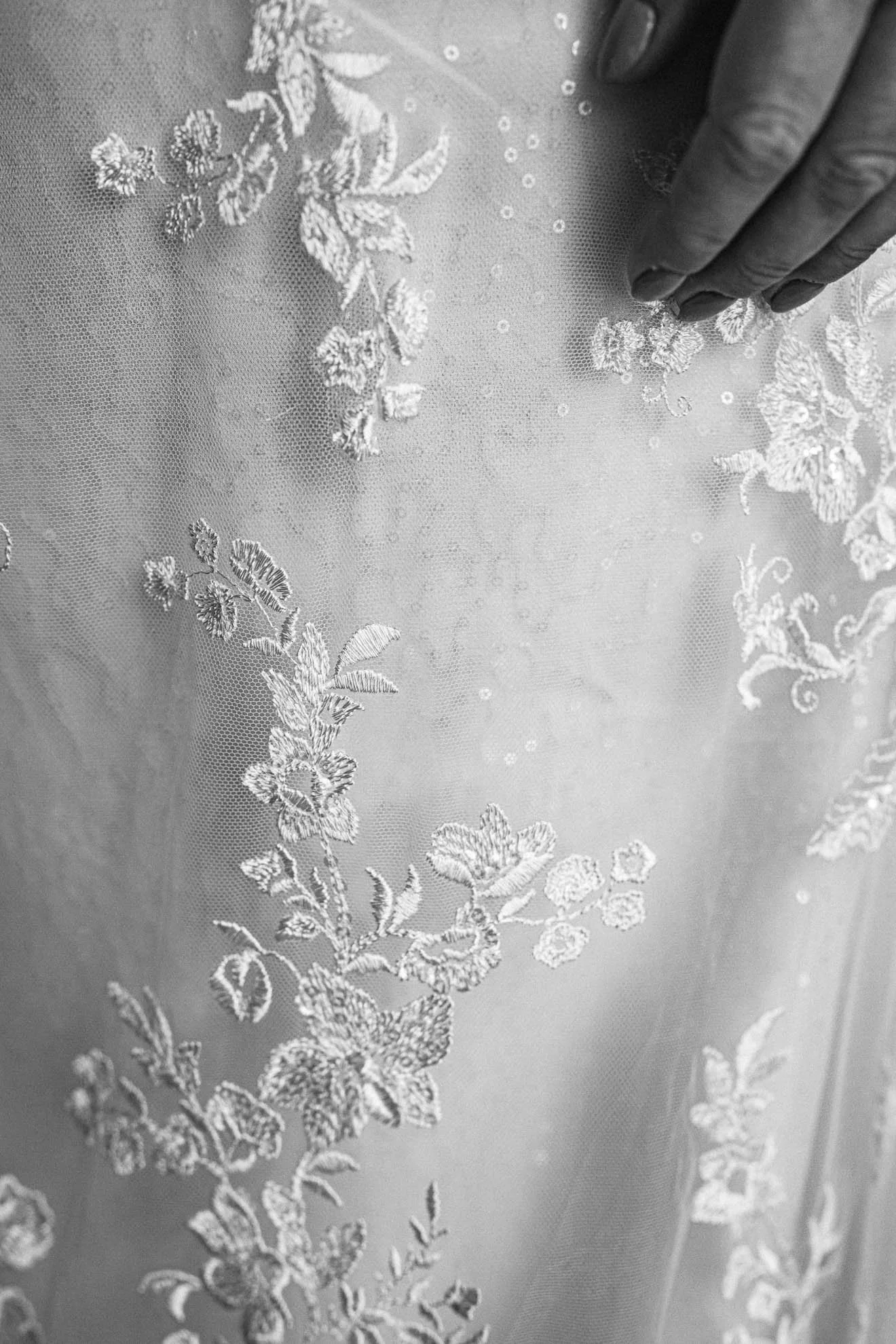 Close-up photo of lace fabric with floral embroidery pattern.