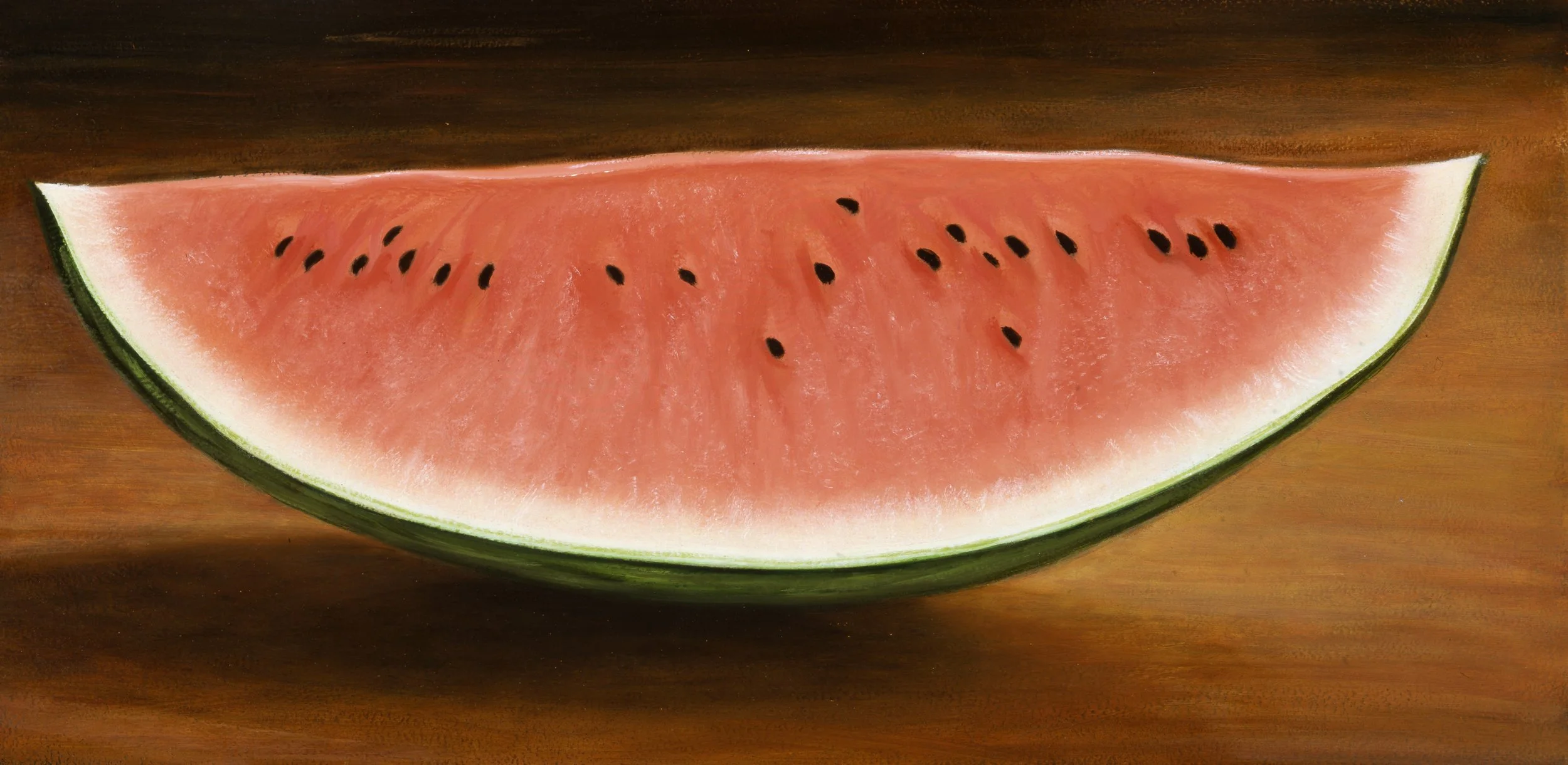 A slice of watermelon with pink flesh and black seeds on a brown wooden surface.
