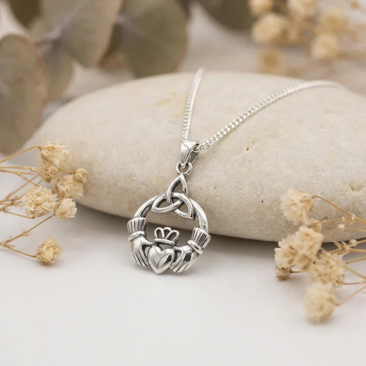 Sterling Silver Claddagh & Trinity Knot Pendant, high mirror polish shown on sea stone with dried botanicals