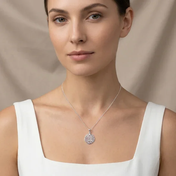 Sterling Silver Celtic Knotwork Disc Pendant, all-over interlaced plaitwork, high mirror polish, shown on model at neckline giving scale