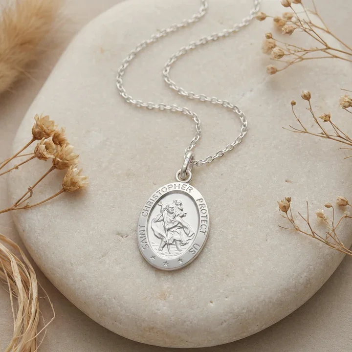 Sterling Silver oval St Christopher pendant. Embossed figural scene, shown on sea stone with dried botanicals