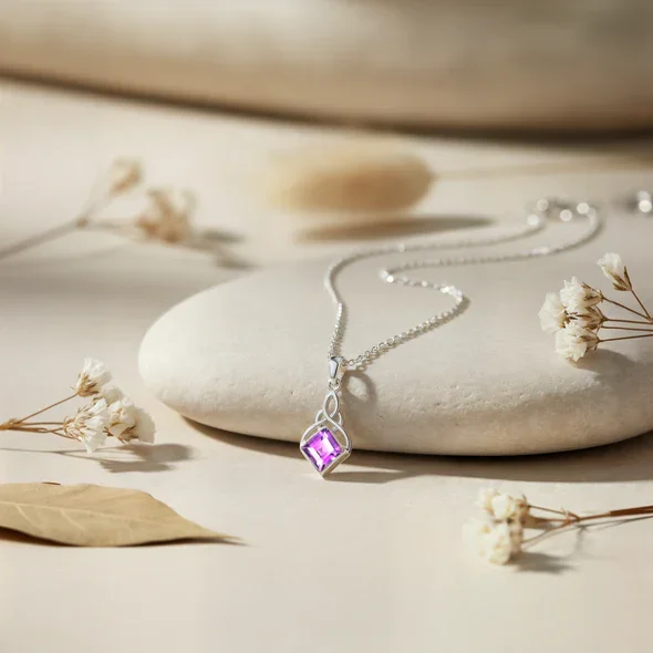 Sterling Silver Celtic Knotwork Pendant, square-cut amethyst stone, bezel set, shown on sea stone with dried botanicals
