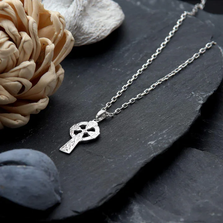 Sterling Silver petite Celtic cross pendant, shown on Scottish slate with sea stones and dried botanicals
