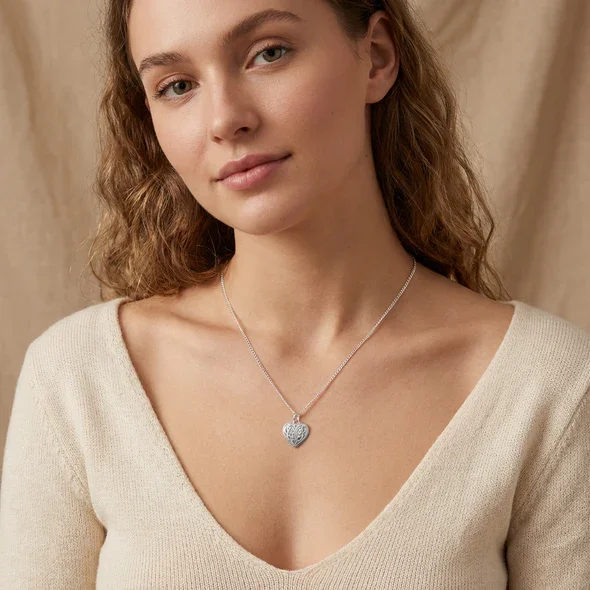 Sterling Silver Celtic Heart Knotwork Pendant, mirrored interlaced interior, high mirror polish, shown on model at neckline giving scale