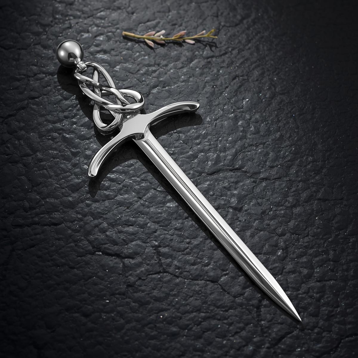 Sterling Silver Scottish sword kilt pin with Celtic knotwork hilt, displayed on dark Scottish slate with dried botanicals