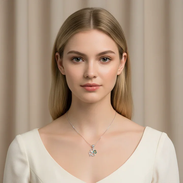 Sterling Silver Celtic Four Leaf Clover Pendant, open heart lobes, green CZ set, shown on model at neckline giving scale