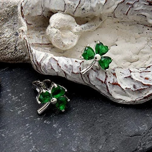 Sterling Silver Celtic Shamrock Stud Earrings, heart-cut green CZ claw set, three-lobe design, push back fitting, shown on Scottish slate with sea stones