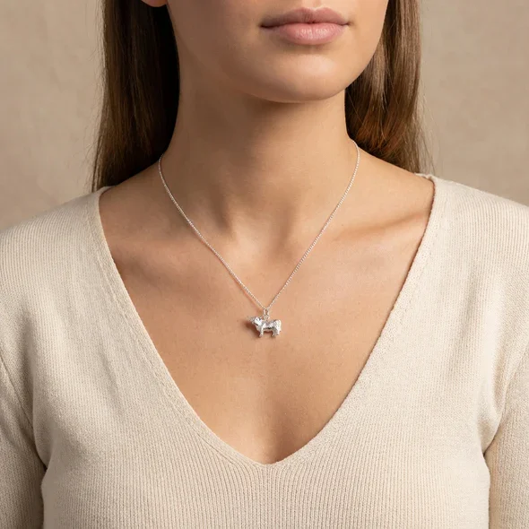 Sterling Silver Scottish Highland Cow Pendant, sculpted three-dimensional form, engraved coat detail, shown on model at neckline giving scale