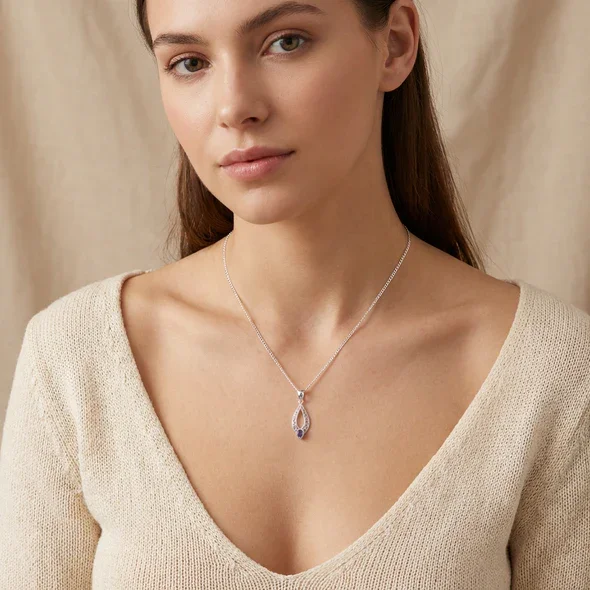 Sterling Silver Celtic Knotwork Navette Pendant, pear-cut amethyst claw set, shown on model at neckline giving scale