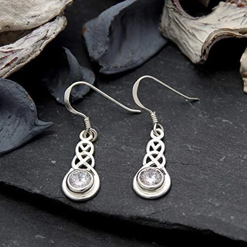 Sterling Silver Celtic Knotwork Drop Earrings, round clear CZ bezel set, high mirror polish, fish hook fitting, shown on Scottish slate with sea stone and dried botanicals