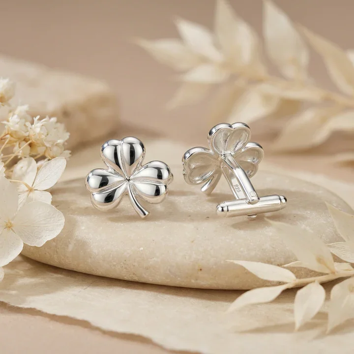 Sterling Silver shamrock cufflinks. Bold sculptural four-leaf clover, domed mirror polish, shown on sea stone with dried botanicals