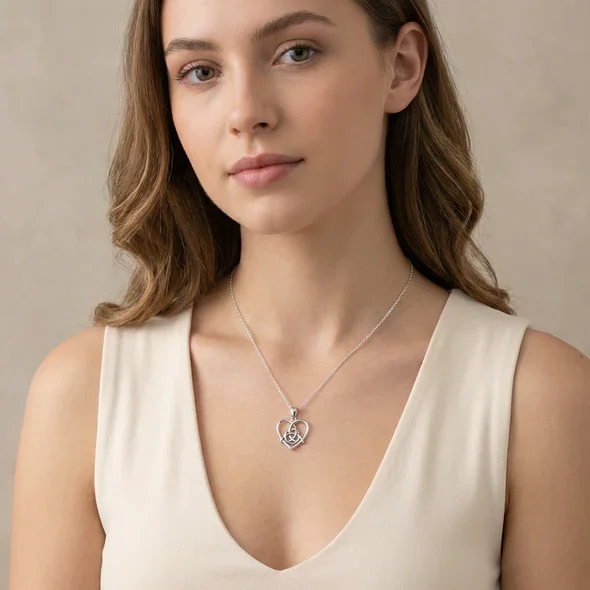Sterling Silver Celtic Trinity Knot Heart Pendant, open heart frame, high mirror polish, shown on model at neckline giving scale