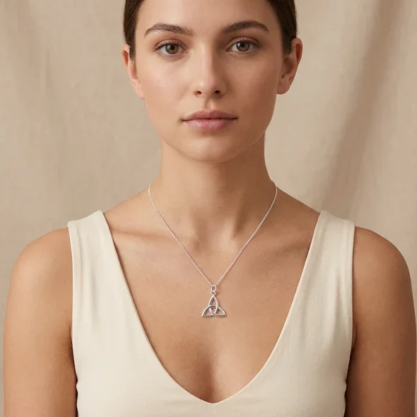 Sterling Silver Celtic Trinity Knot Pendant, open triquetra design, high mirror polish, shown on model neckline giving scale