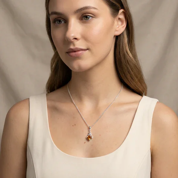 Sterling Silver Celtic Knotwork Pendant, natural amber square-cut stone, bezel set, shown on model at neckline giving scale