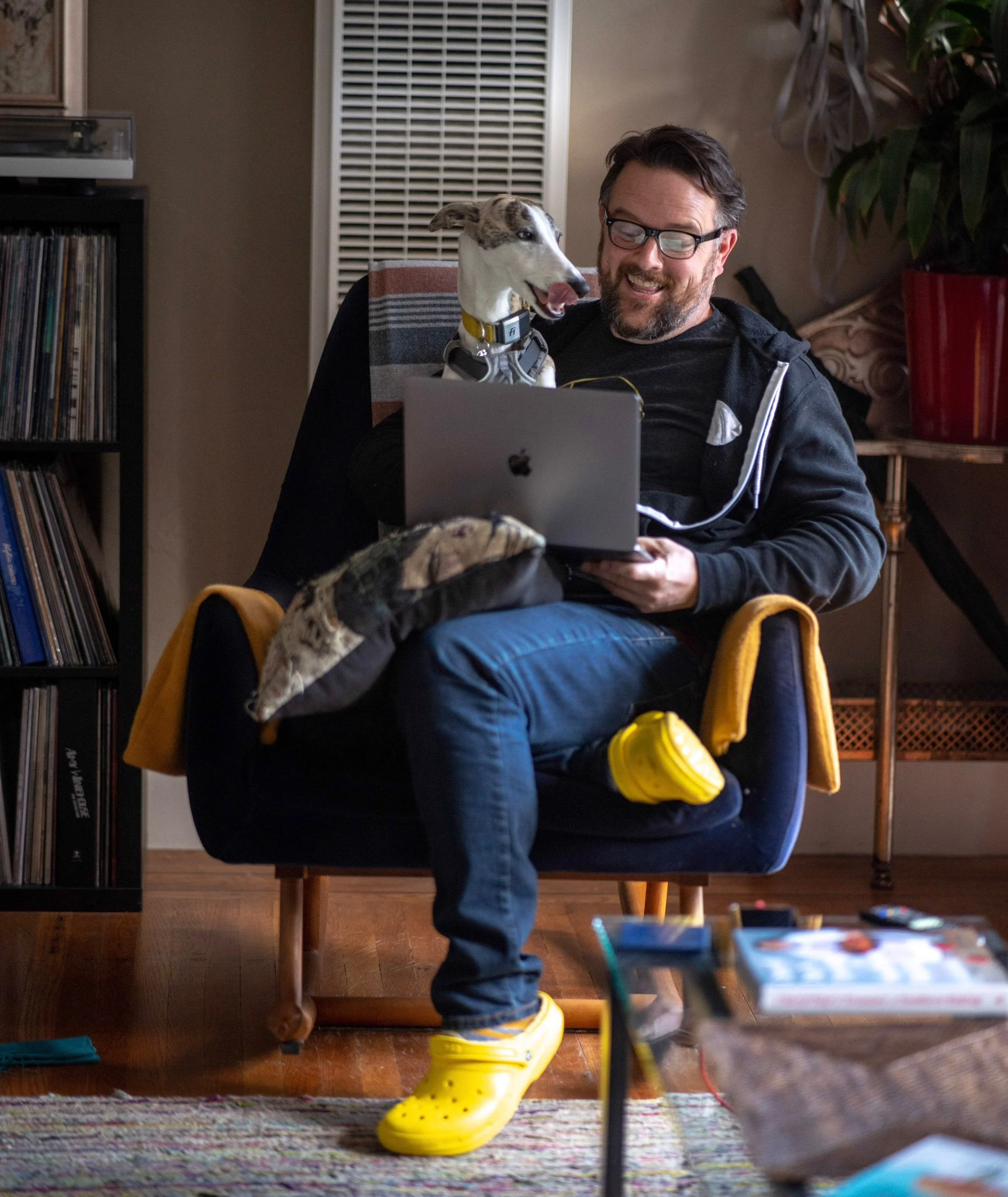 Joe Hayes working from home in Noe Valley with a dog on his lap, highlighting his dog sitting, training, and brand consulting work.