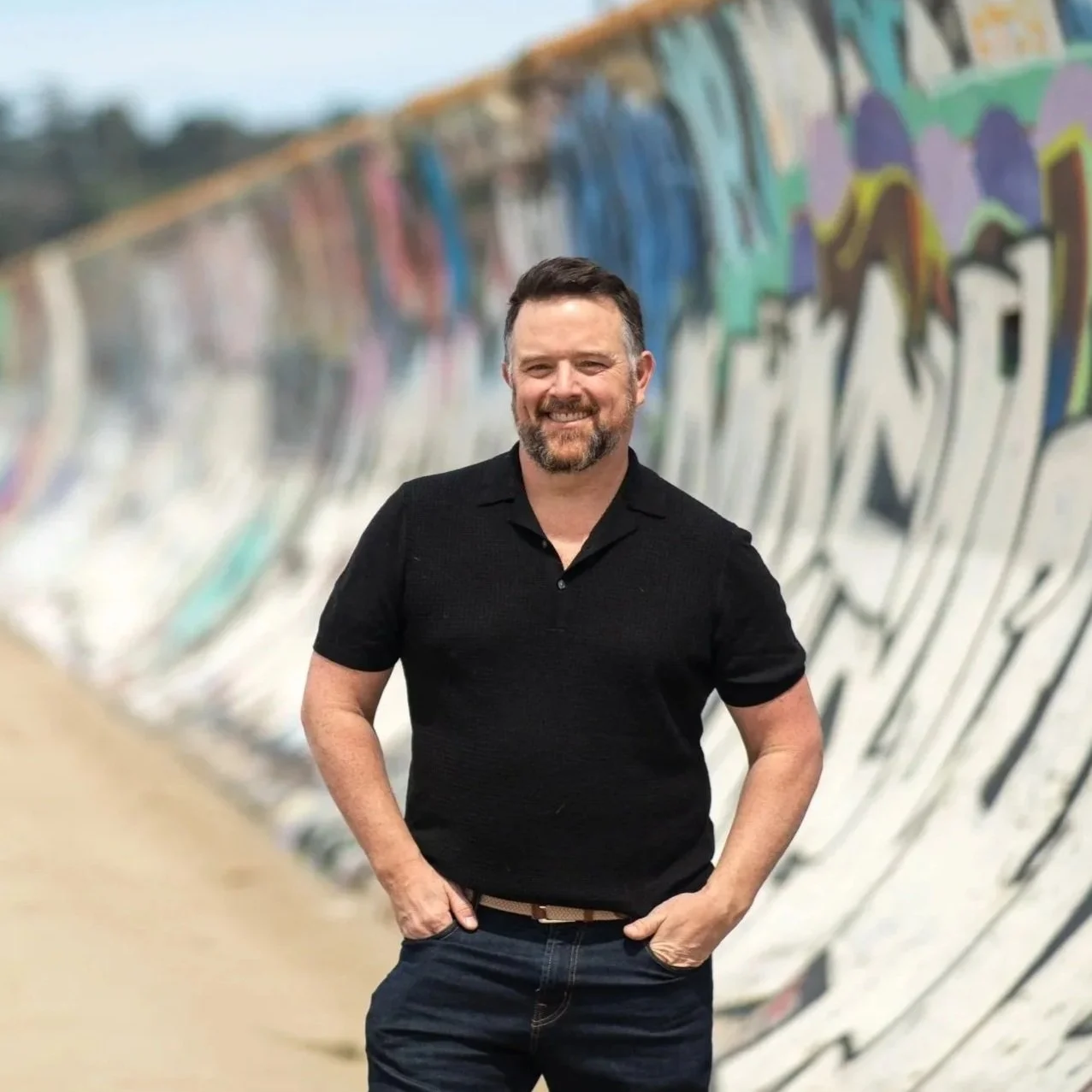 Joe Hayes, brand and employee experience consultant, standing outdoors against a graffiti-covered wall in San Francisco.