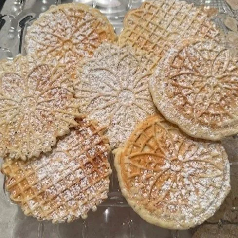 A plate of assorted waffles dusted with powdered sugar.