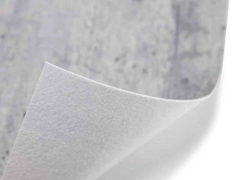 Nahaufnahme eines weißen Papierbogens auf grauem Hintergrund.