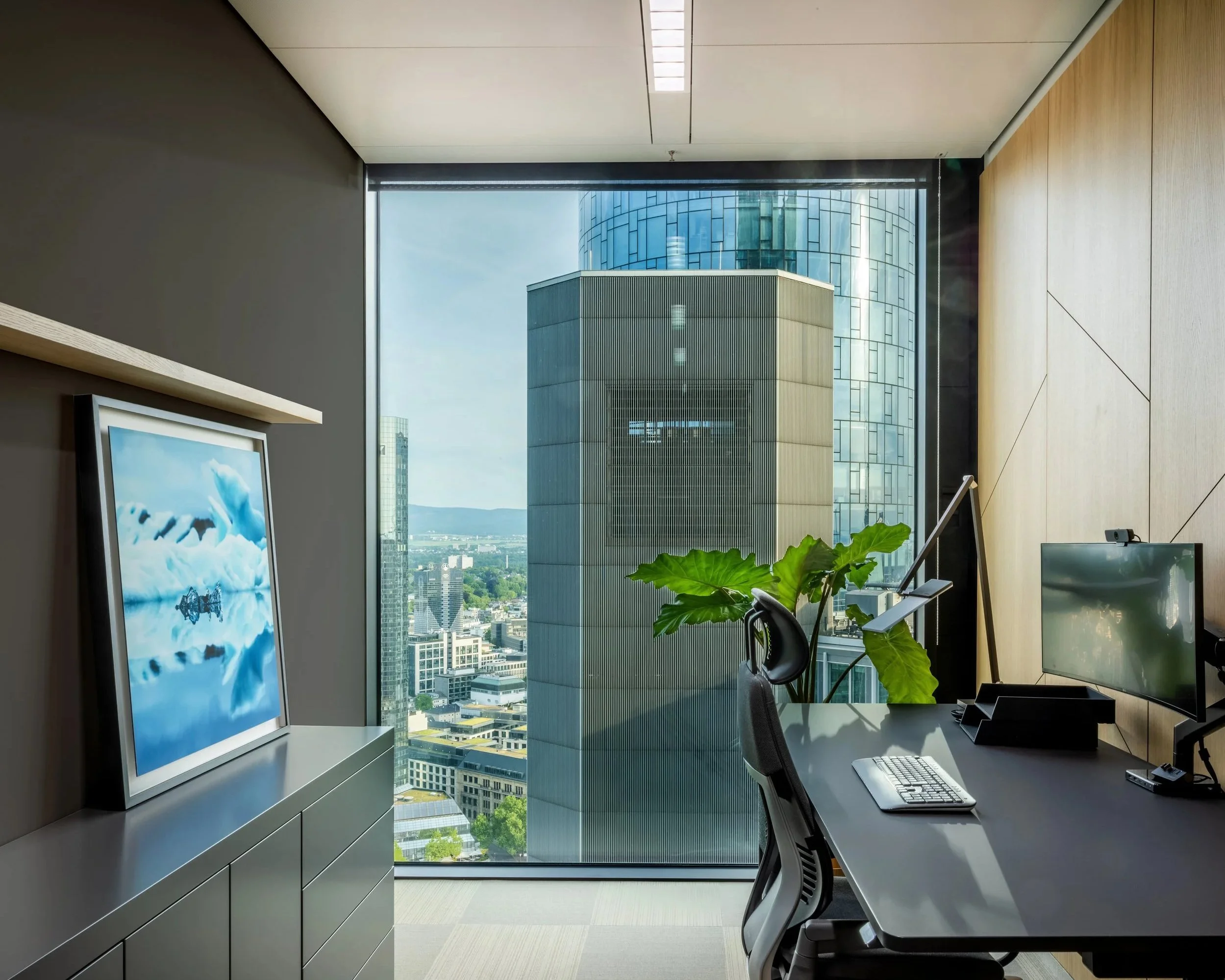 Moderner Büroarbeitsplatz mit Skyline-Blick und dunklem Schreibtisch – Innenarchitektur