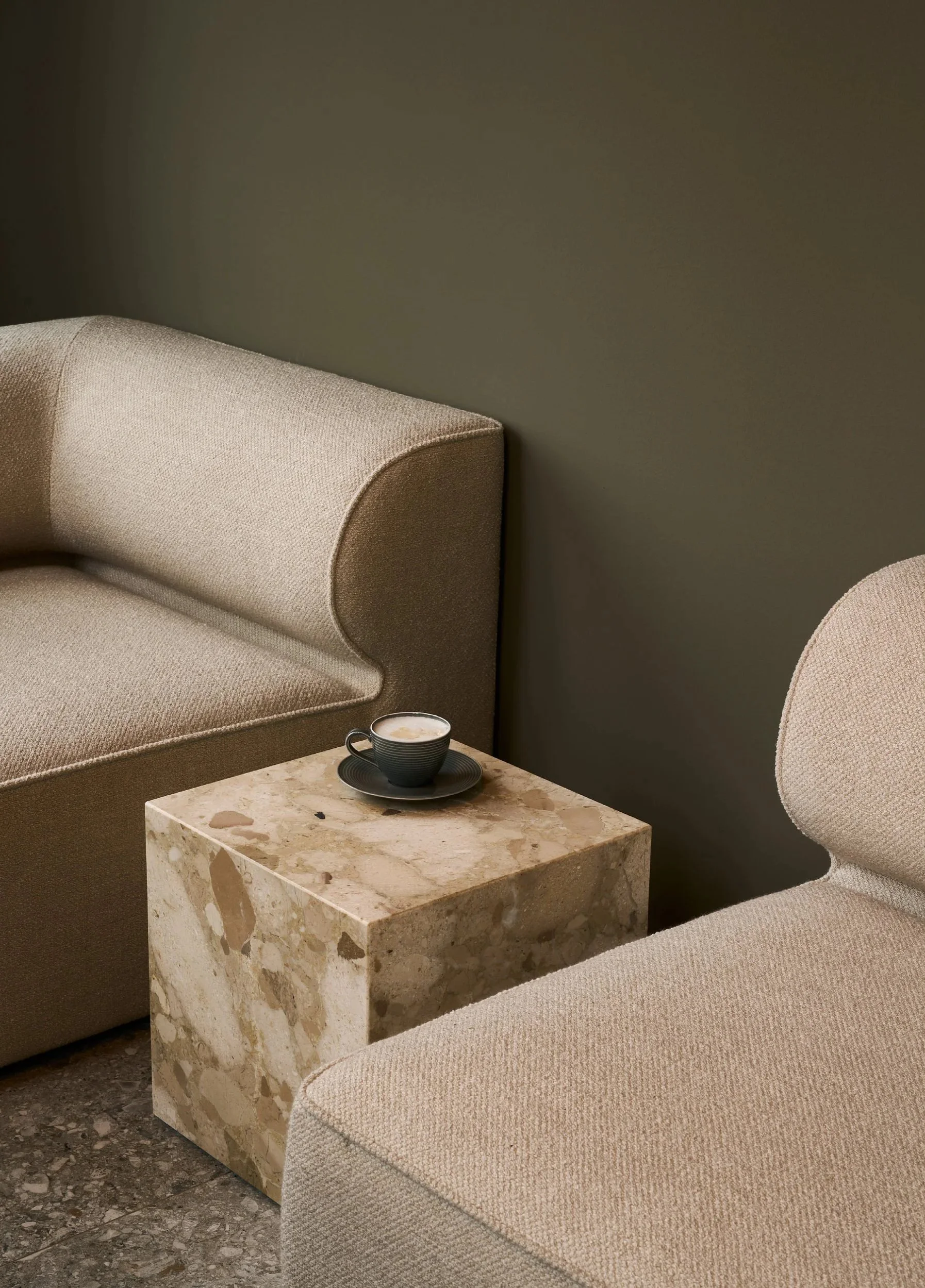 Beiges Polstersofa mit Marmor-Couchtisch vor grüner Wand – Innenarchitektur